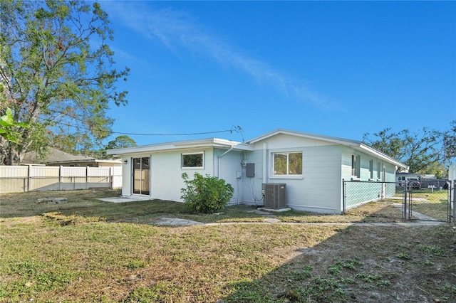 back of house with a lawn and central air condition unit