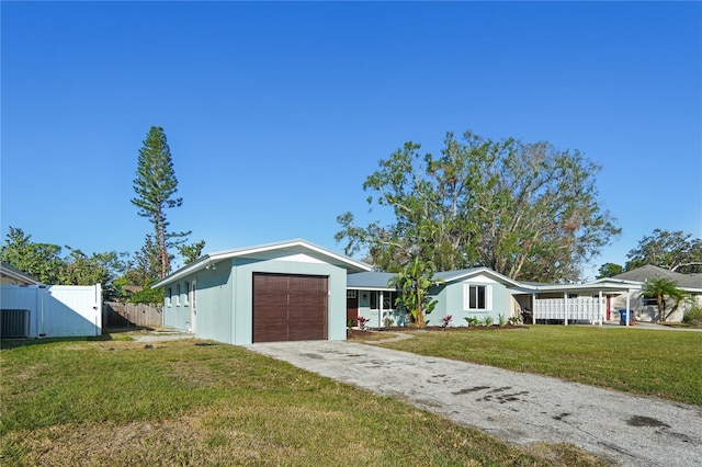 single story home featuring a garage, a front lawn, and central air condition unit