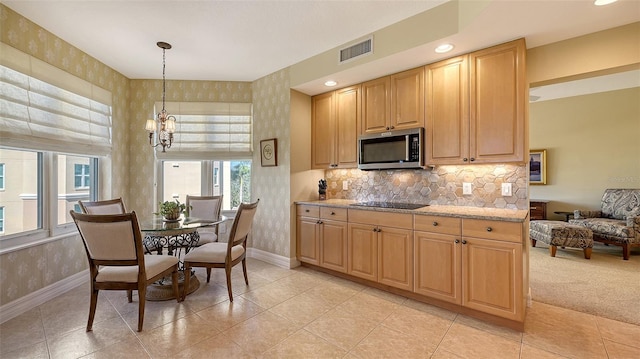 kitchen featuring pendant lighting, an inviting chandelier, backsplash, light stone counters, and black electric stovetop