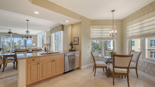 kitchen featuring dishwasher, sink, pendant lighting, and a notable chandelier