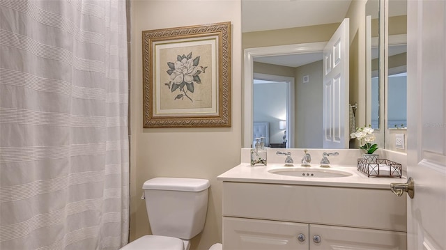 bathroom featuring vanity, toilet, and curtained shower