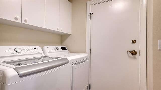 washroom with cabinets and washing machine and dryer