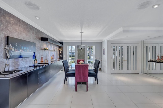 tiled dining area with french doors, ornamental molding, and a textured ceiling