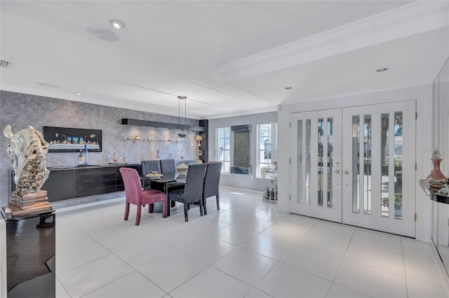 dining area featuring french doors, ornamental molding, and light tile patterned flooring