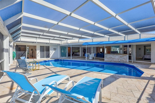 view of pool featuring an outdoor bar, glass enclosure, and a patio area