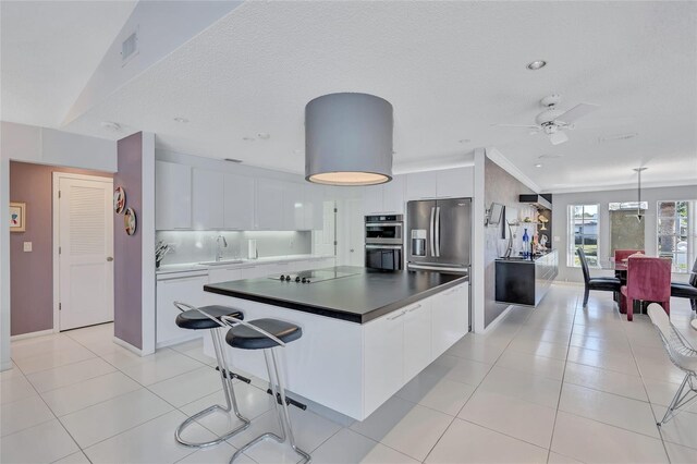 kitchen with white cabinetry, sink, a kitchen island, and appliances with stainless steel finishes