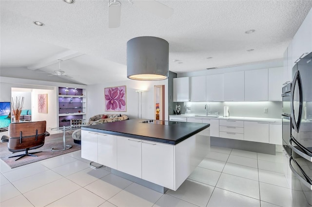 kitchen featuring sink, ceiling fan, white cabinetry, black appliances, and a kitchen island