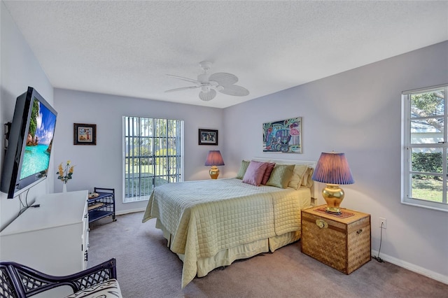 carpeted bedroom with multiple windows, ceiling fan, access to outside, and a textured ceiling