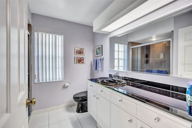 bathroom featuring walk in shower, vanity, toilet, and tile patterned flooring