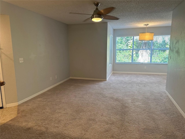 carpeted empty room featuring ceiling fan and a textured ceiling