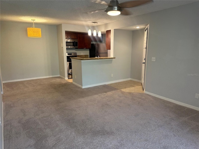 kitchen featuring light carpet, hanging light fixtures, kitchen peninsula, and appliances with stainless steel finishes