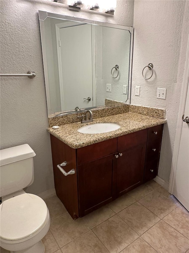 bathroom with vanity, tile patterned floors, and toilet