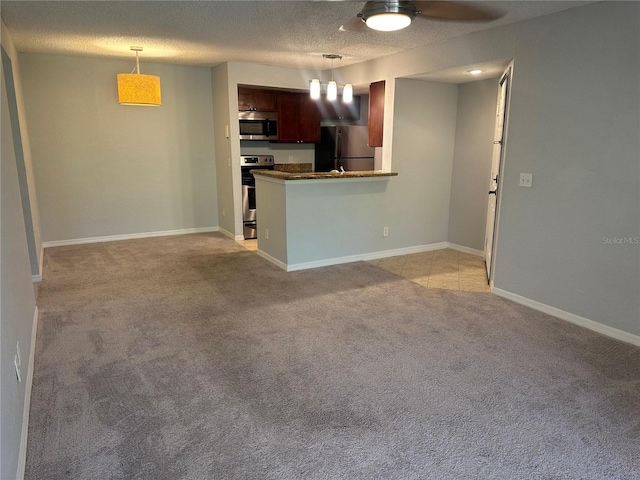 unfurnished living room featuring ceiling fan, light colored carpet, and a textured ceiling