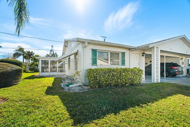 view of side of property with a lawn and a sunroom