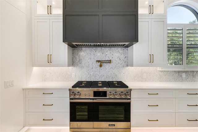 kitchen with a wealth of natural light, stainless steel range with gas stovetop, and white cabinets