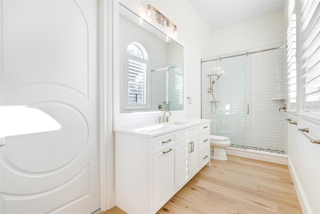 bathroom with vanity, hardwood / wood-style floors, an enclosed shower, and toilet