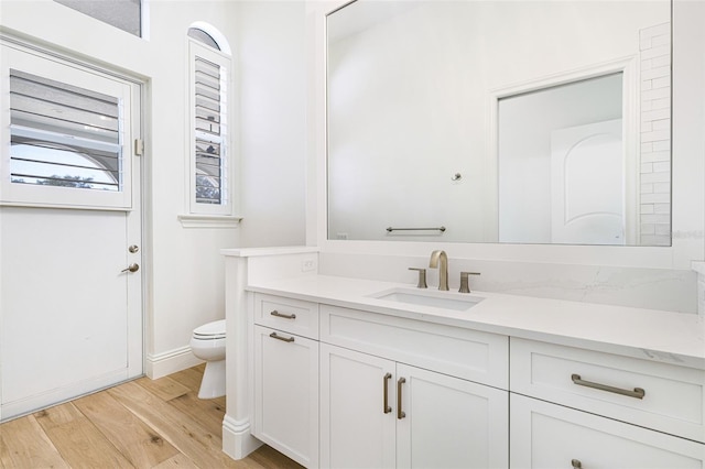 bathroom featuring hardwood / wood-style flooring, vanity, and toilet