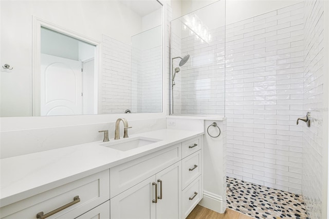 bathroom featuring vanity, tiled shower, and hardwood / wood-style floors