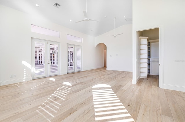 unfurnished room with high vaulted ceiling, light hardwood / wood-style floors, french doors, and ceiling fan