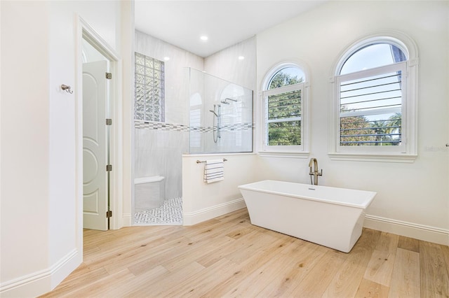 bathroom featuring hardwood / wood-style flooring and independent shower and bath