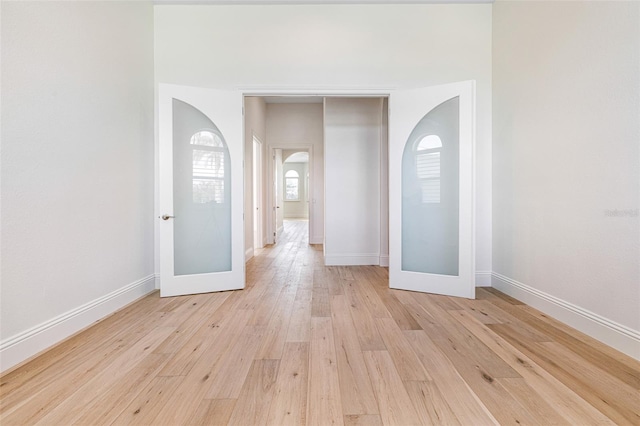 unfurnished room featuring french doors and light wood-type flooring