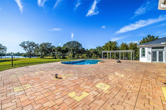 view of pool with a pergola, a patio area, and a water view