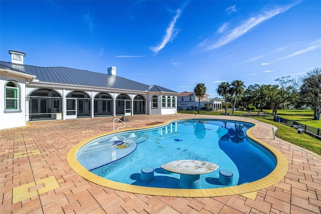 view of pool with a patio area and a sunroom