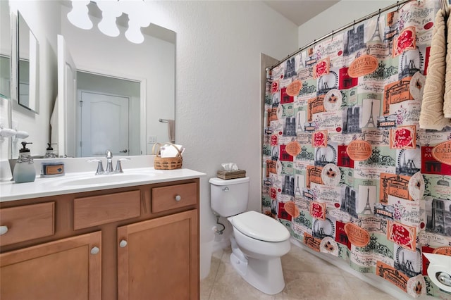 bathroom with tile patterned flooring, vanity, toilet, and walk in shower