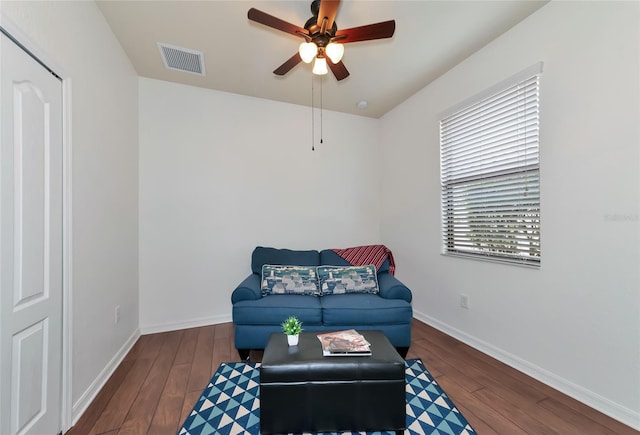 living area featuring dark hardwood / wood-style flooring and ceiling fan