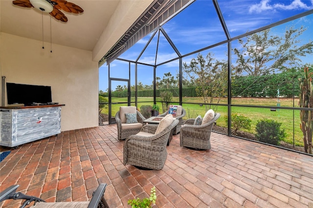 view of patio / terrace with ceiling fan, an outdoor hangout area, and glass enclosure