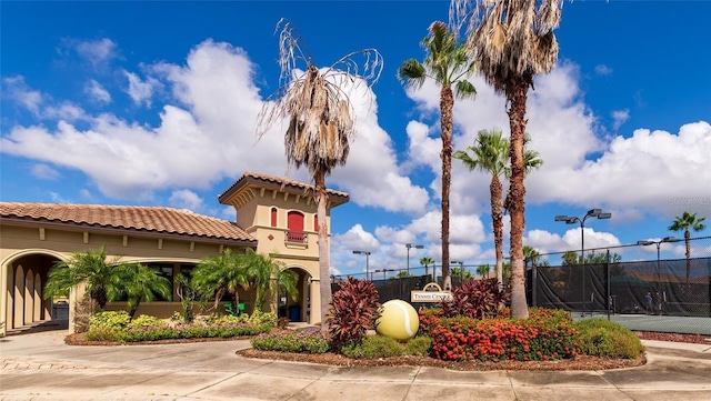 view of front of property featuring tennis court