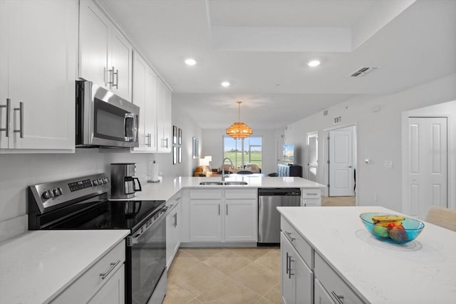 kitchen featuring sink, white cabinetry, decorative light fixtures, kitchen peninsula, and stainless steel appliances