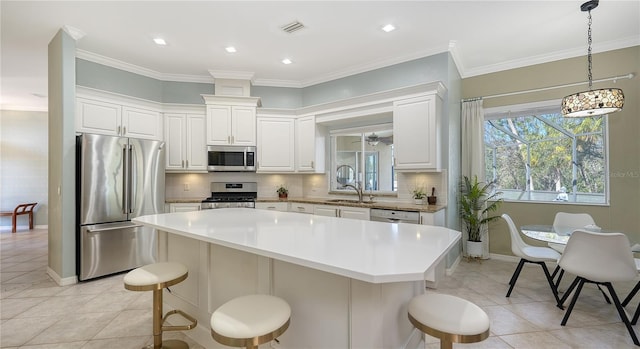 12471 Natureview Cir, Bradenton, FL 34212 - kitchen with appliances with stainless steel finishes, light tile patterned flooring, a kitchen island, tasteful backsplash, and crown molding