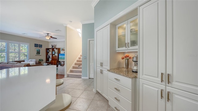 12471 Natureview Cir, Bradenton, FL 34212 - kitchen with a ceiling fan, light tile patterned flooring, glass insert cabinets, crown molding, and white cabinetry