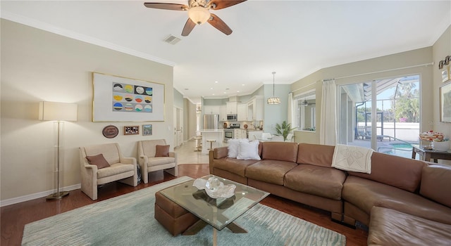 12471 Natureview Cir, Bradenton, FL 34212 - living room featuring a ceiling fan, wood finished floors, baseboards, and ornamental molding