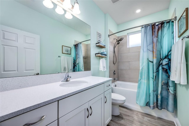 full bathroom with hardwood / wood-style flooring, vanity, shower / bath combination with curtain, and toilet