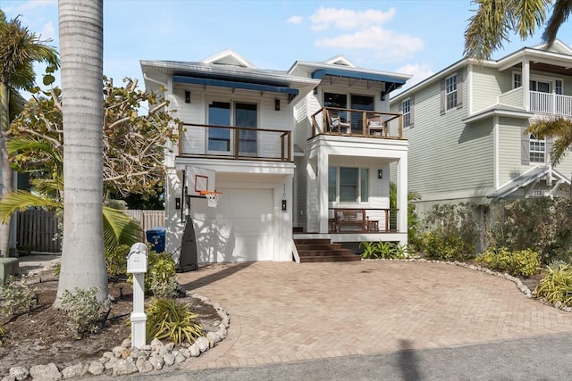 view of front of home featuring a garage, a balcony, and covered porch