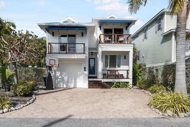 view of front of property with a garage, a balcony, and a porch