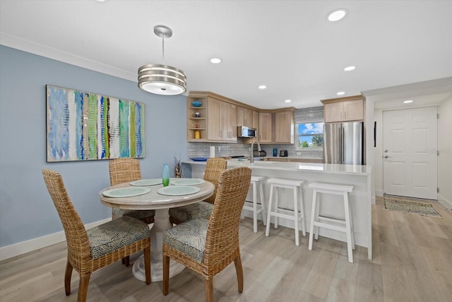 dining area featuring sink and light hardwood / wood-style flooring