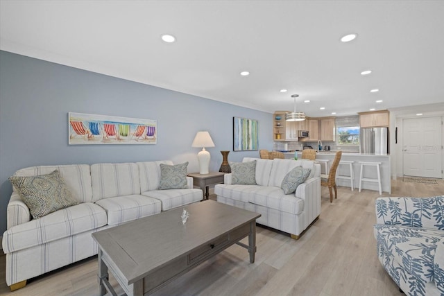 living room with sink and light hardwood / wood-style flooring