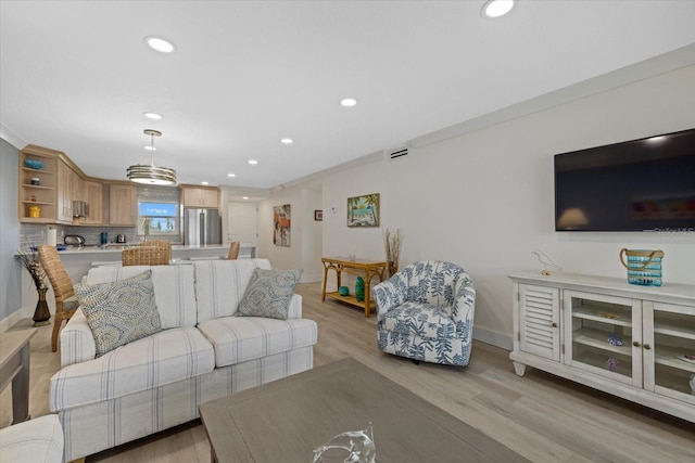 living room featuring ornamental molding and light wood-type flooring