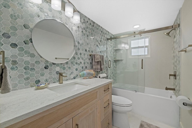 full bathroom with vanity, decorative backsplash, shower / bath combination with glass door, and toilet