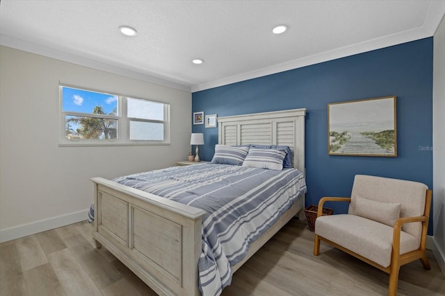 bedroom featuring ornamental molding and light wood-type flooring