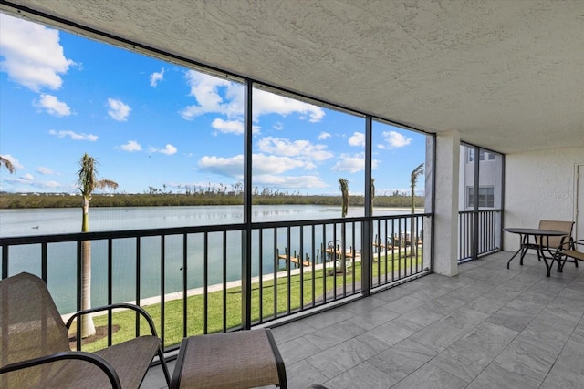 sunroom / solarium featuring a water view