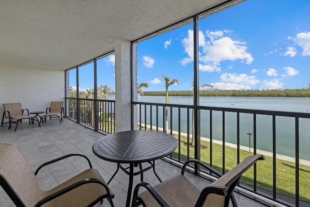 sunroom / solarium featuring a water view