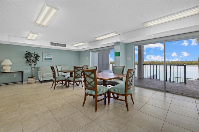 dining space featuring a textured ceiling and light tile patterned floors