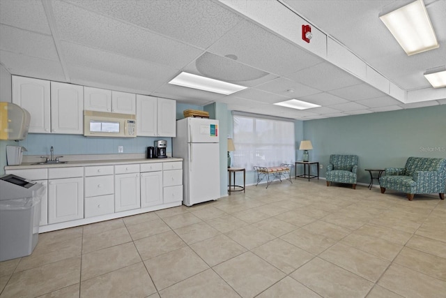 kitchen featuring sink, a paneled ceiling, white cabinets, and white appliances