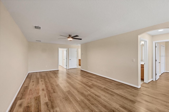 spare room featuring a textured ceiling, ceiling fan, and light wood-type flooring