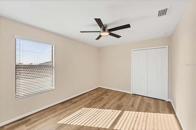 unfurnished bedroom featuring a closet, ceiling fan, and light wood-type flooring