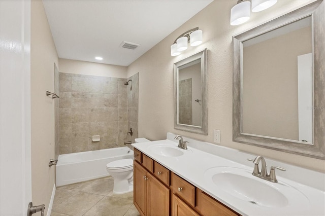 full bathroom with vanity, tiled shower / bath combo, tile patterned floors, and toilet